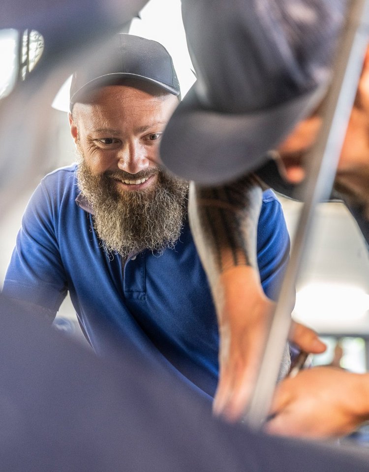 Zwei Werkstattmitarbeiter von Autohaus Biggel arbeiten an einem Auto